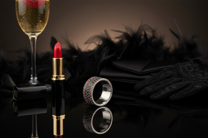 Black and red pavé ring perspective - glamorous evening: red lipstick, champagne, black accessories, romantic light